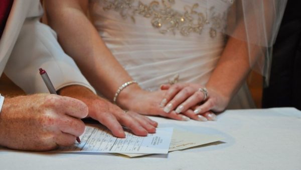 Couple signing a marriage licence at Price Creek Event Center, the best Eastern Iowa Wedding Venue in Amana Iowa just minutes away from Iowa City and Cedar Rapids.