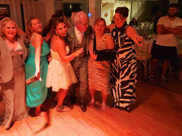 A group of guests dancing together on the reception floor during one of our hosted weddings. The image captures the joyful, high-energy atmosphere of the evening, showcasing our venue’s ability to bring people together for memorable celebrations. The lighting highlights the lively party environment where friends and family are enjoying the music and festivities, reflecting the relaxed and fun experience we strive to provide for every couple and their guests.